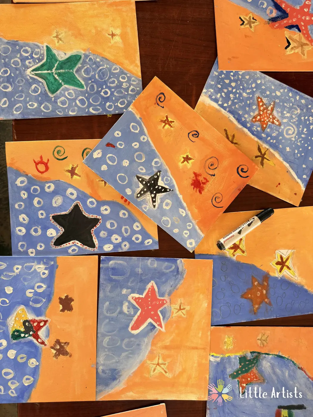 A table covered in the students' finished starfish paintings