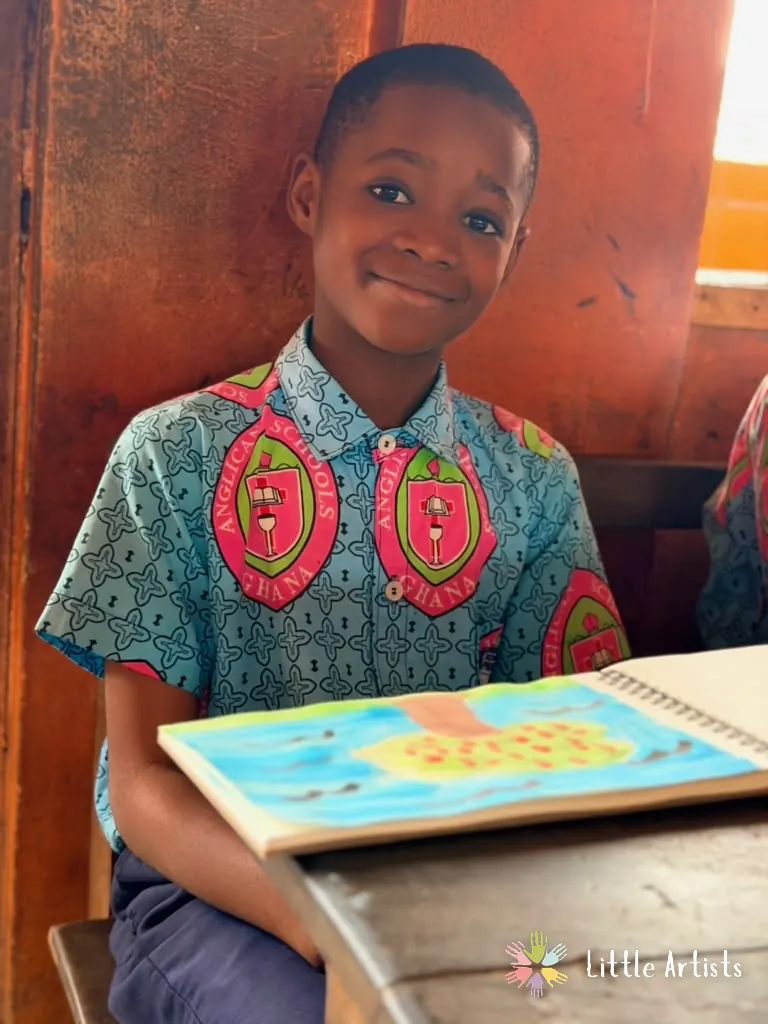A student in his school uniform holding the painting he made