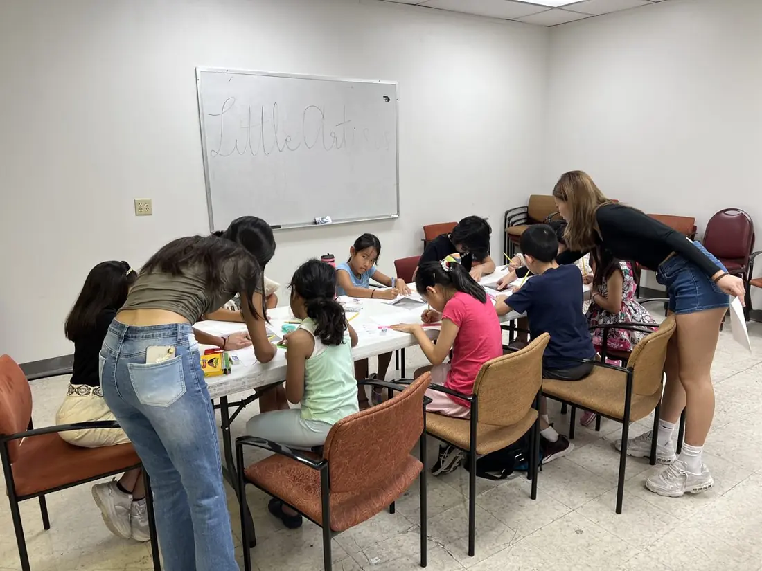 Students and teen mentors working on art together at a Little Artists session